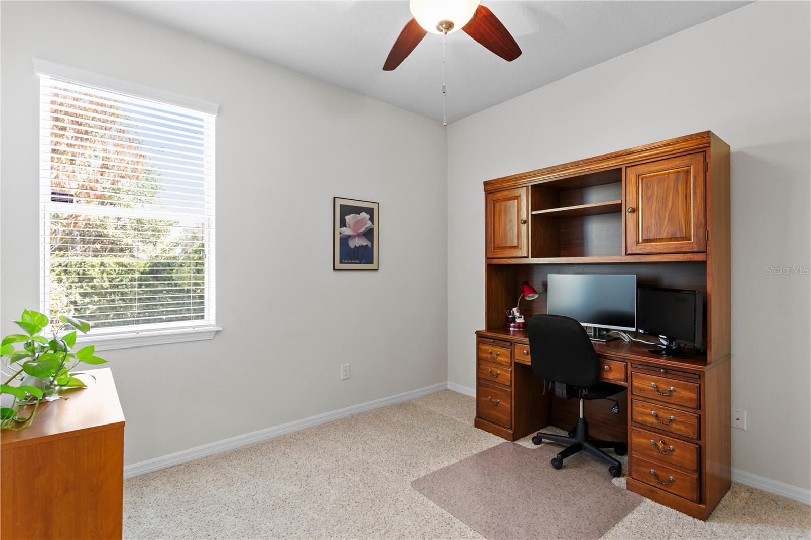 Bedroom 2 with ceiling fan currently set up as a home office