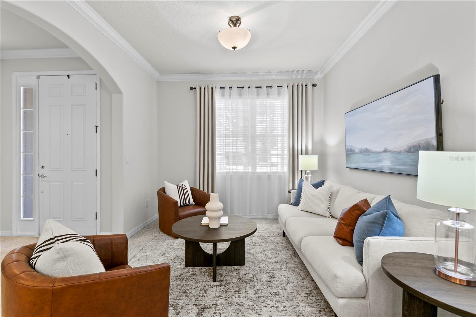 Front living room with graceful arches and carpet flooring