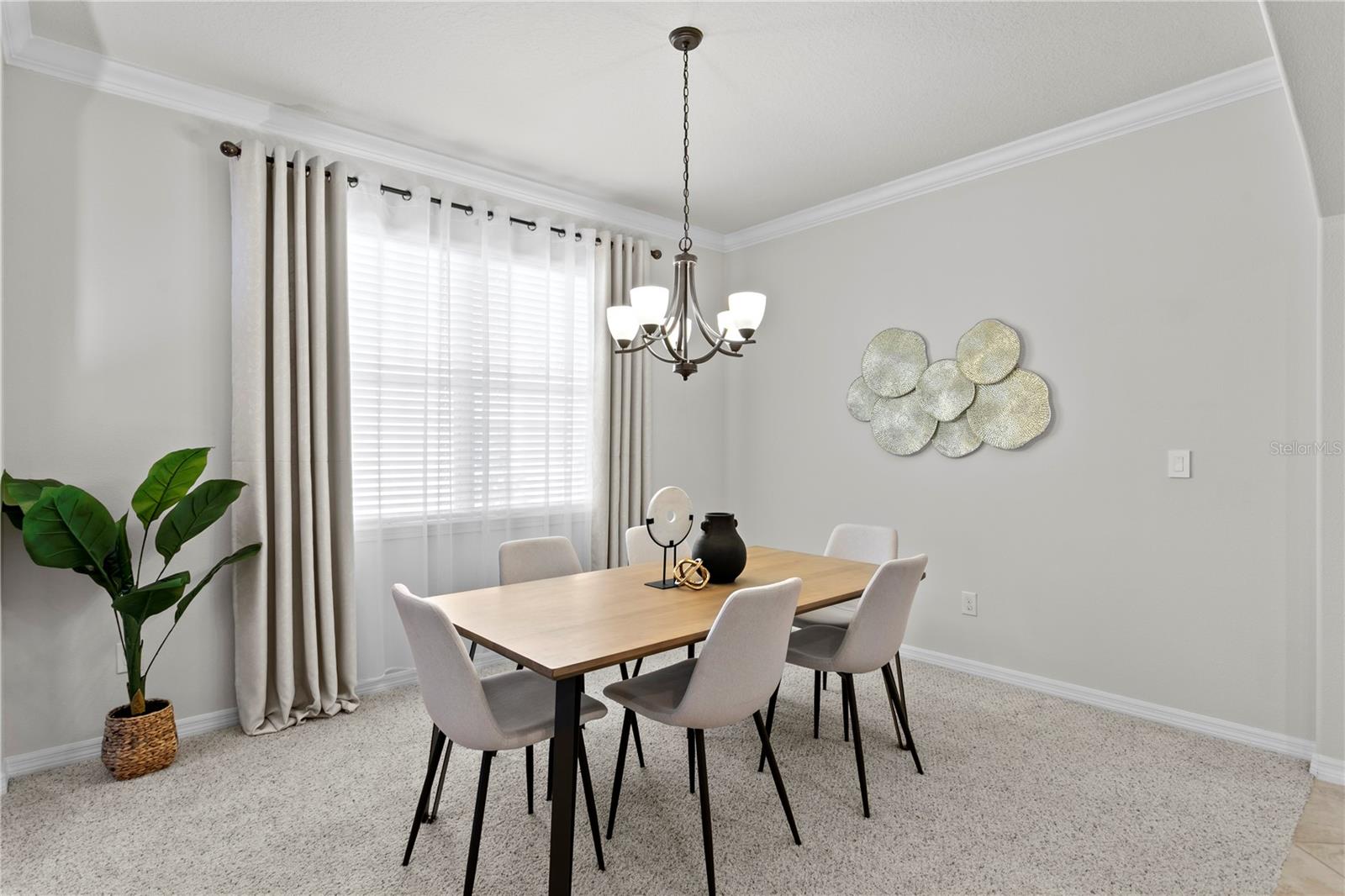 Dining room features crown molding and window treatments
