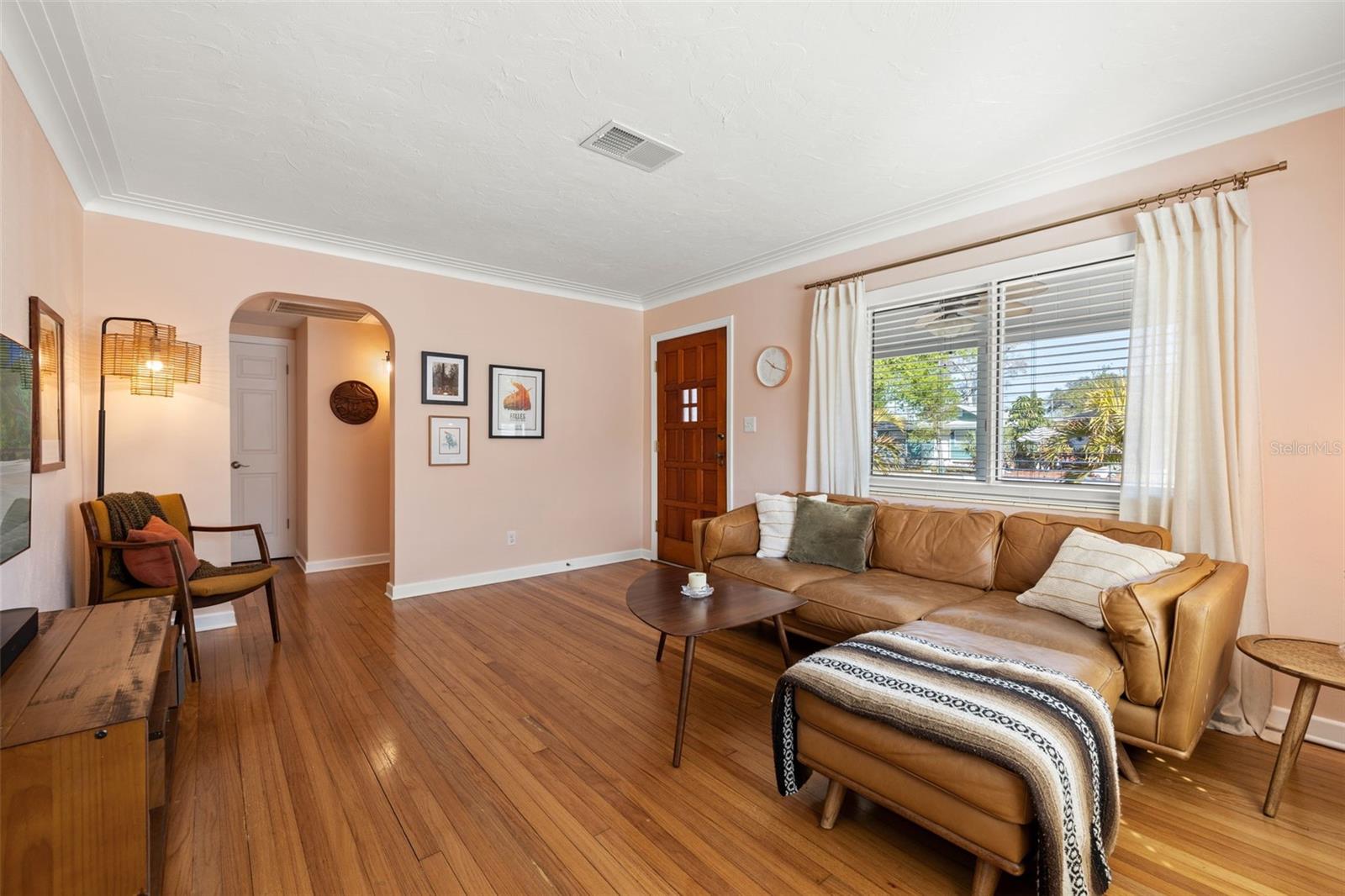 Large front-facing windows fill the space with natural light while highlighting the beautiful hardwood flooring throughout.