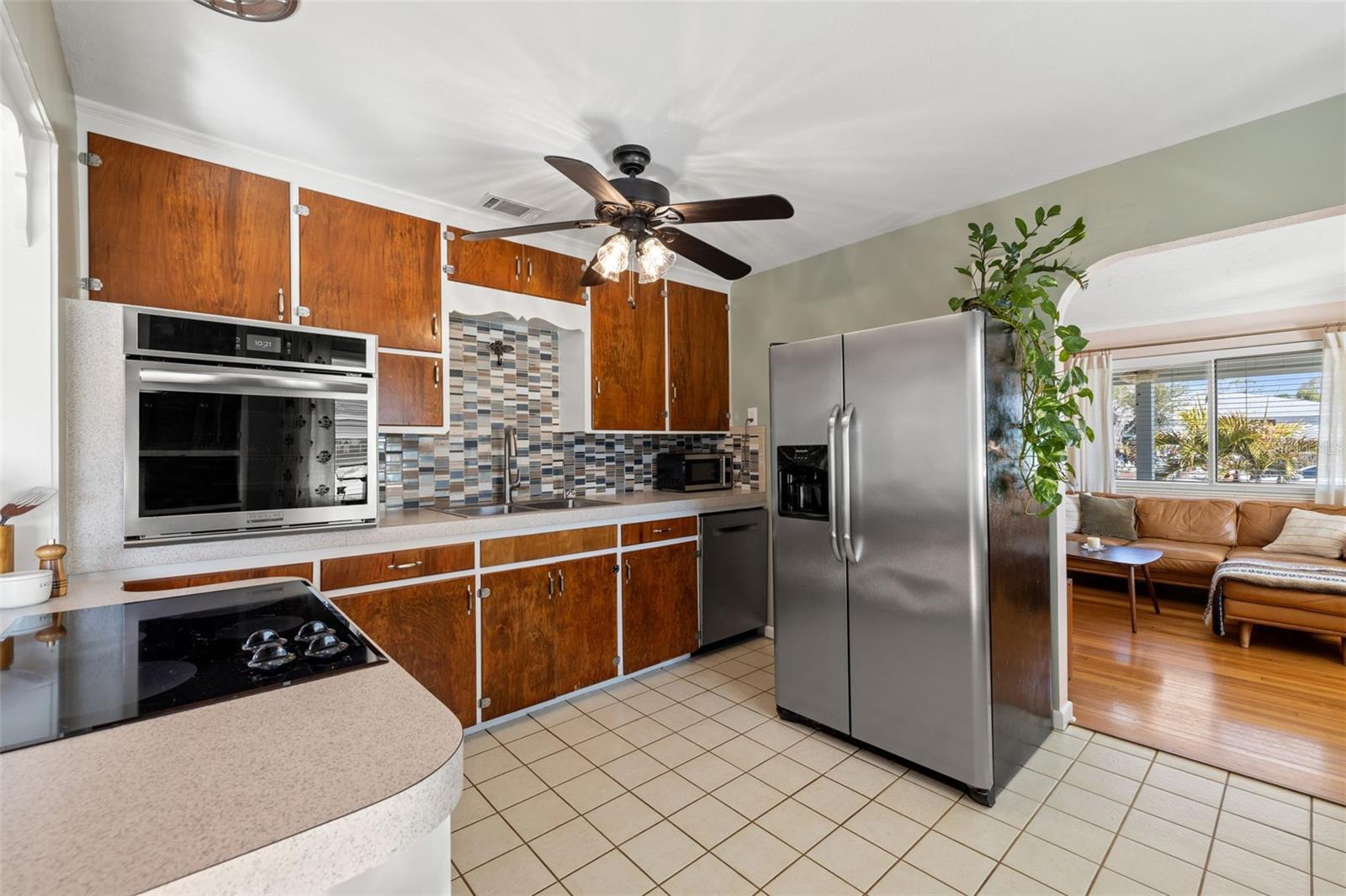 Well-appointed kitchen with ample wood cabinetry, tile flooring, stainless steel refrigerator, and a convenient breakfast bar for casual dining.