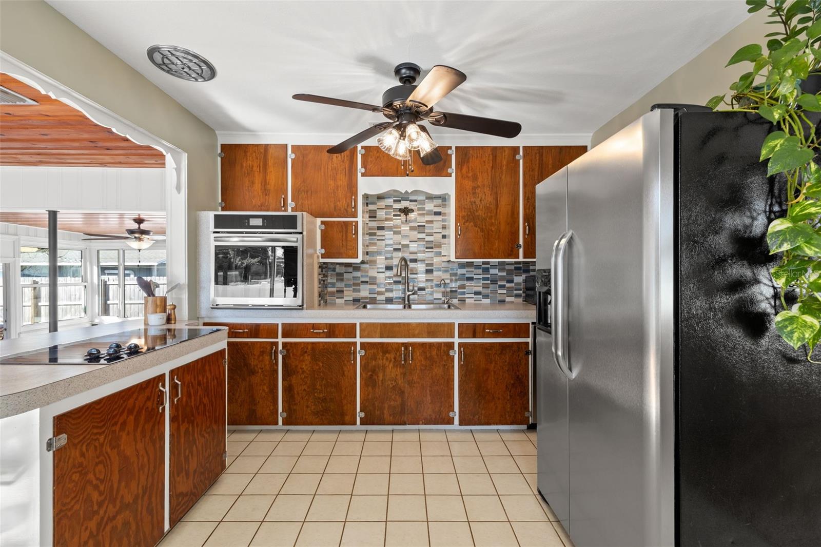 Stainless refrigerator, range, and microwave with classic cabinet design.