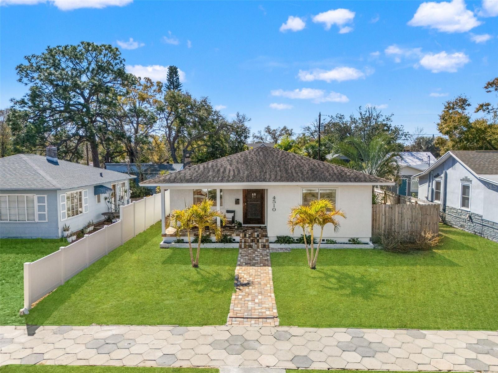 A paved brick walkway leads to the front entry, creating a polished and inviting approach to the home.