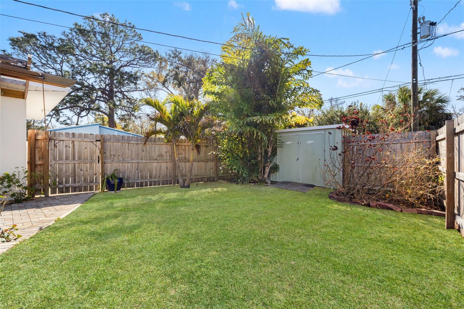Fenced yard with room for dining, pets, or garden beds.
