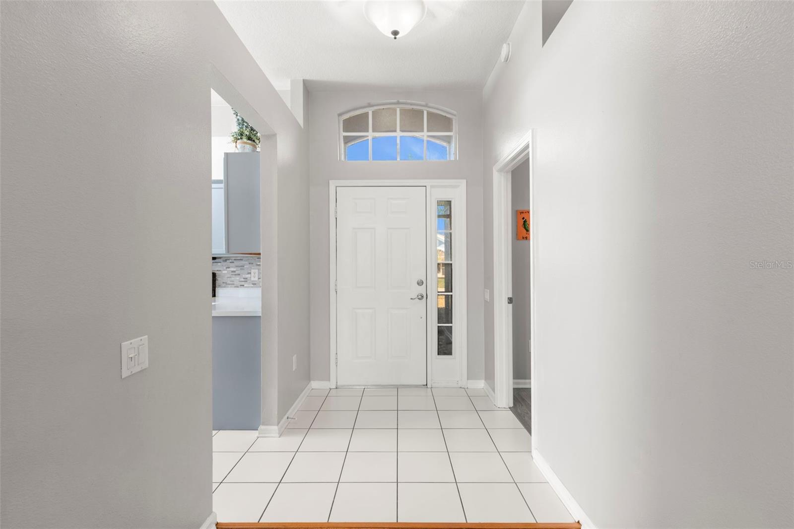 View of the front door, kitchen to the left and bedroom 2 or office to the right