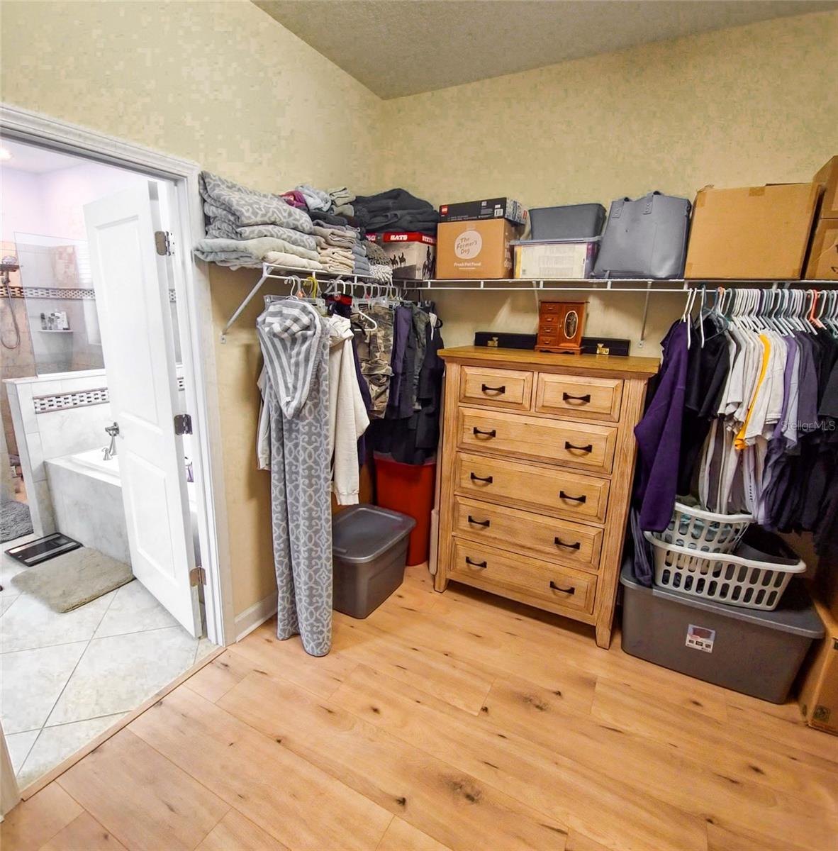 Primary walk-in closet view into primary bathroom
