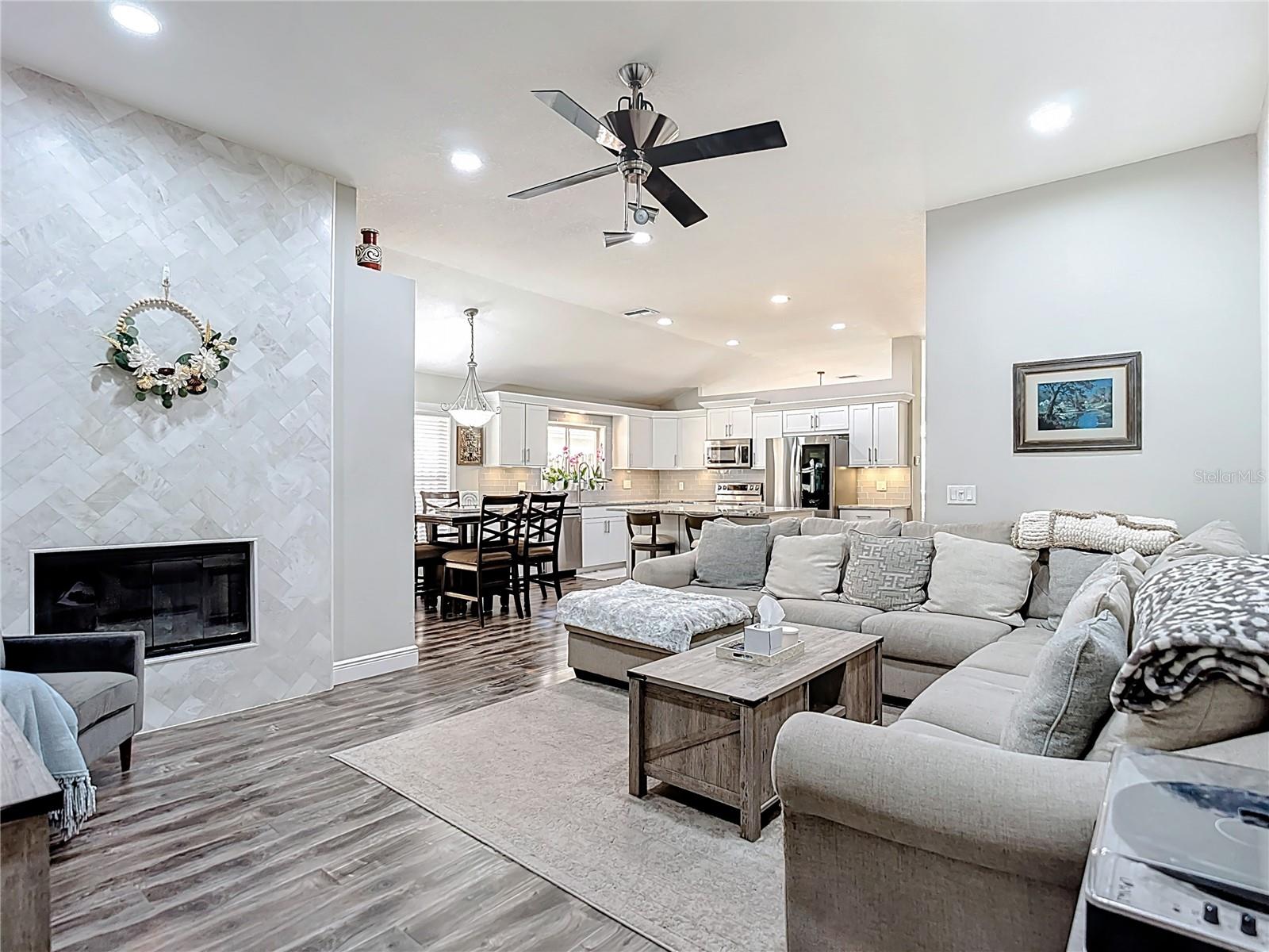 The family room features a charming wood-burning fireplace updated with white marble tile in a beautiful herringbone pattern — creating a warm and inviting focal point.