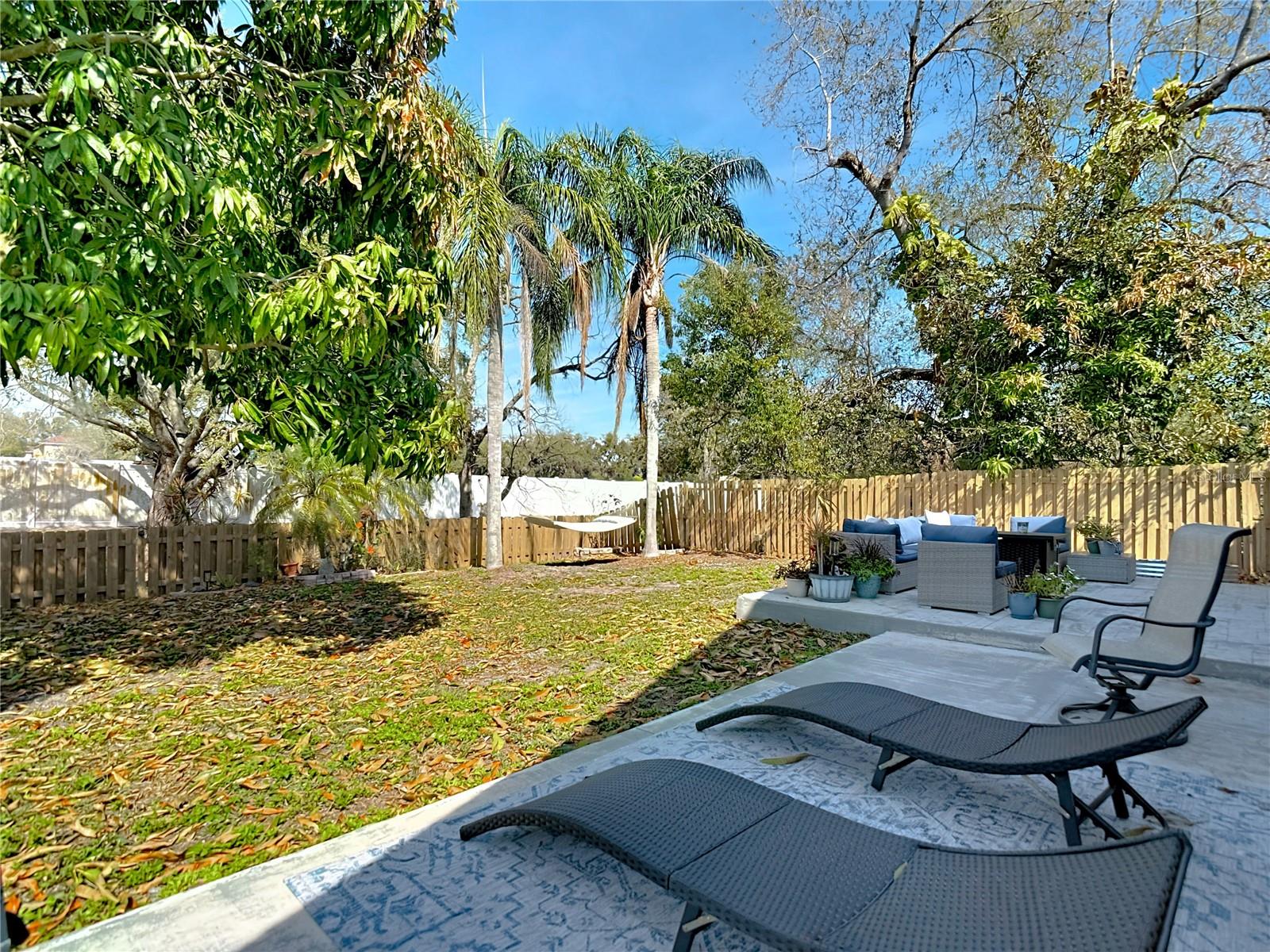 Step outside to your fully fenced backyard with wood privacy fencing and mature landscaping.