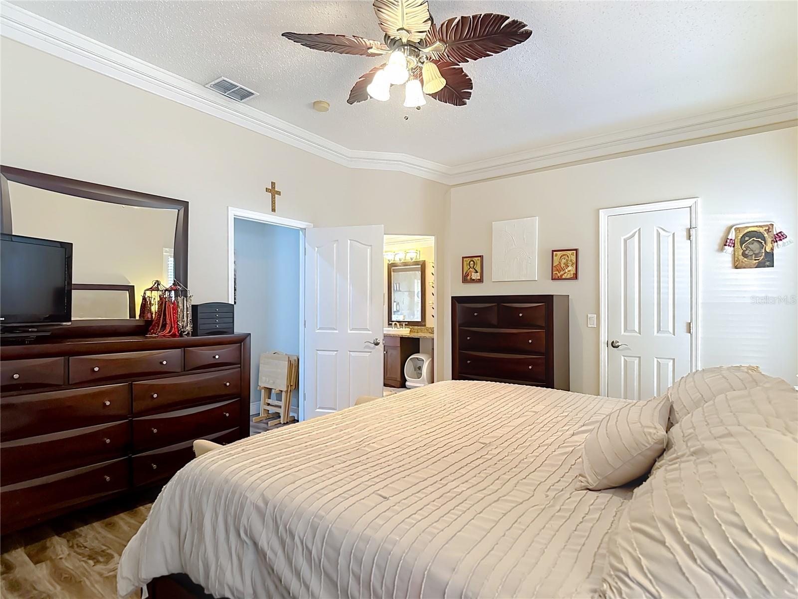 The spacious primary suite includes a walk-in closet and an en-suite bathroom with granite countertops, double sinks, and a walk-in shower.