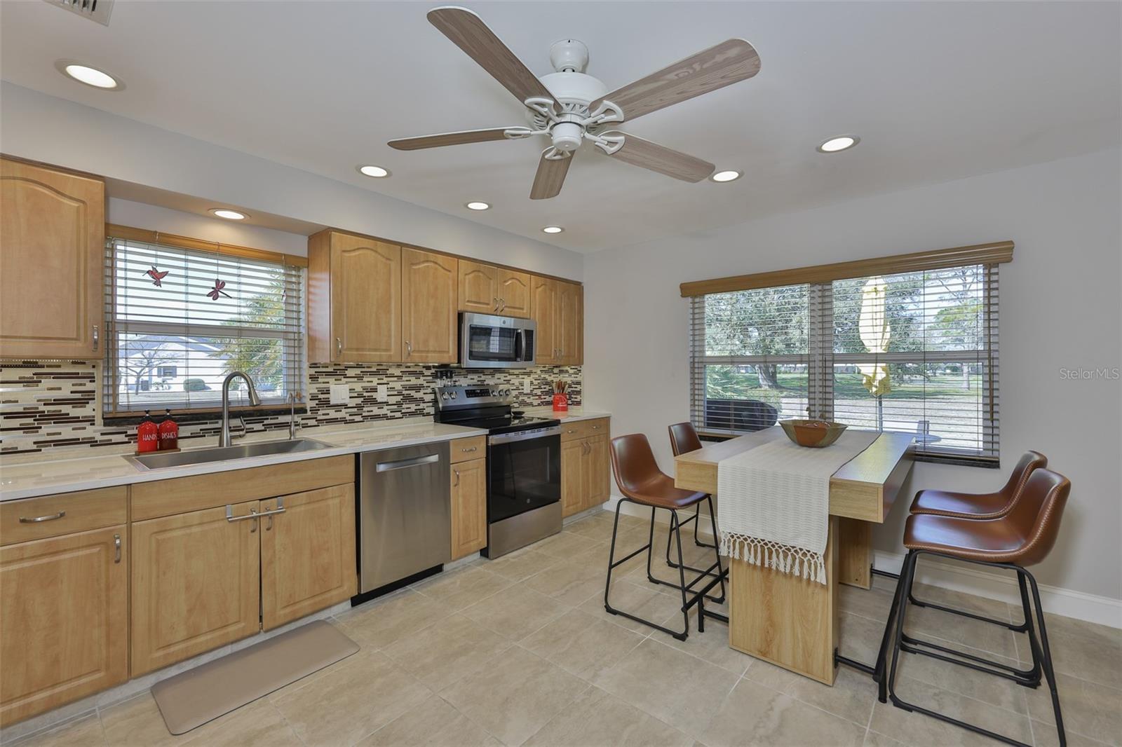 Beautiful all wood cabinets, modern backsplash, lovely stainless steel appliances and large windows make this space extremely enjoyable.