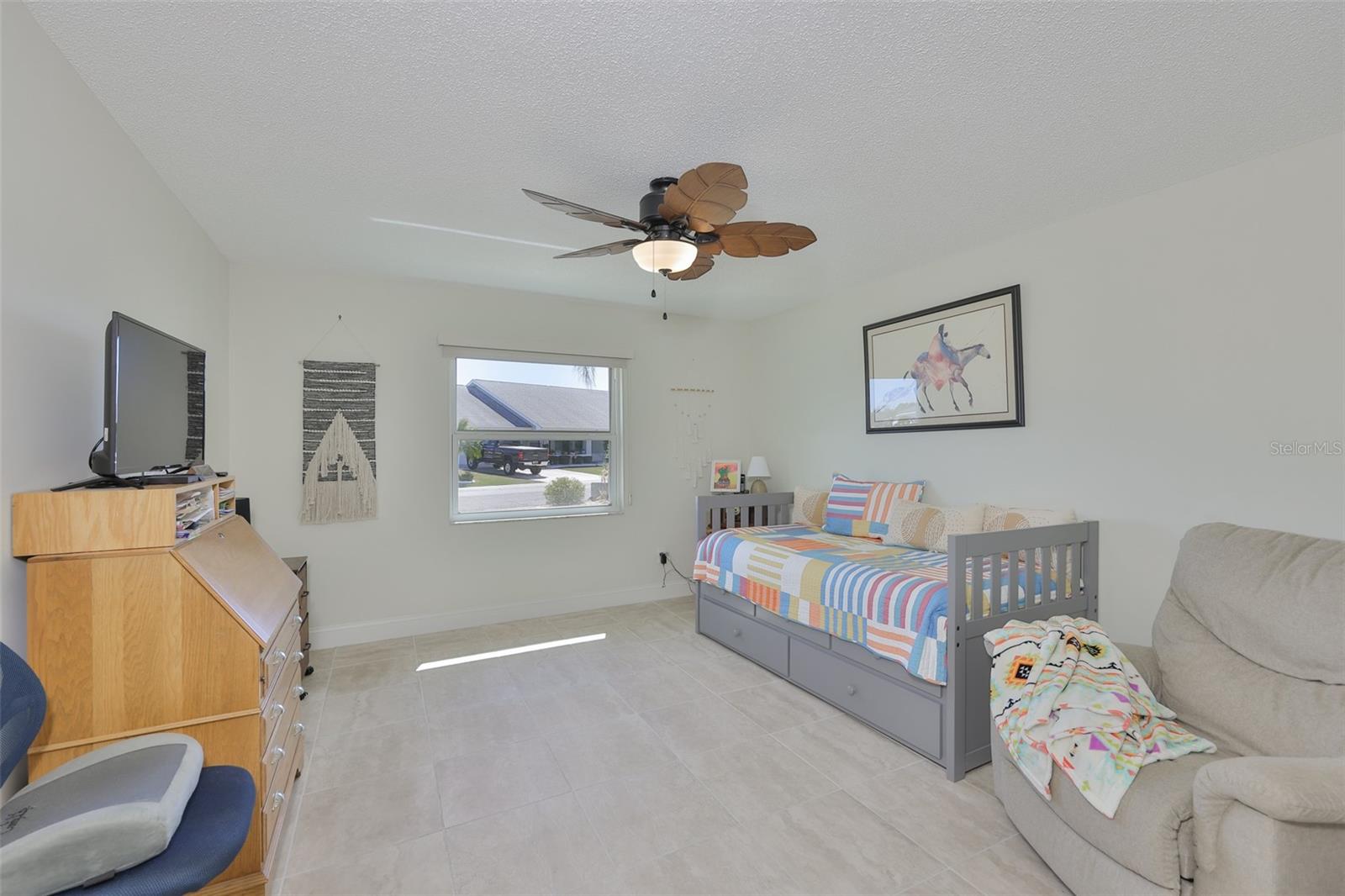 The guest bedroom also has the beautiful tile flooring with a large window for natural Florida sunshine.