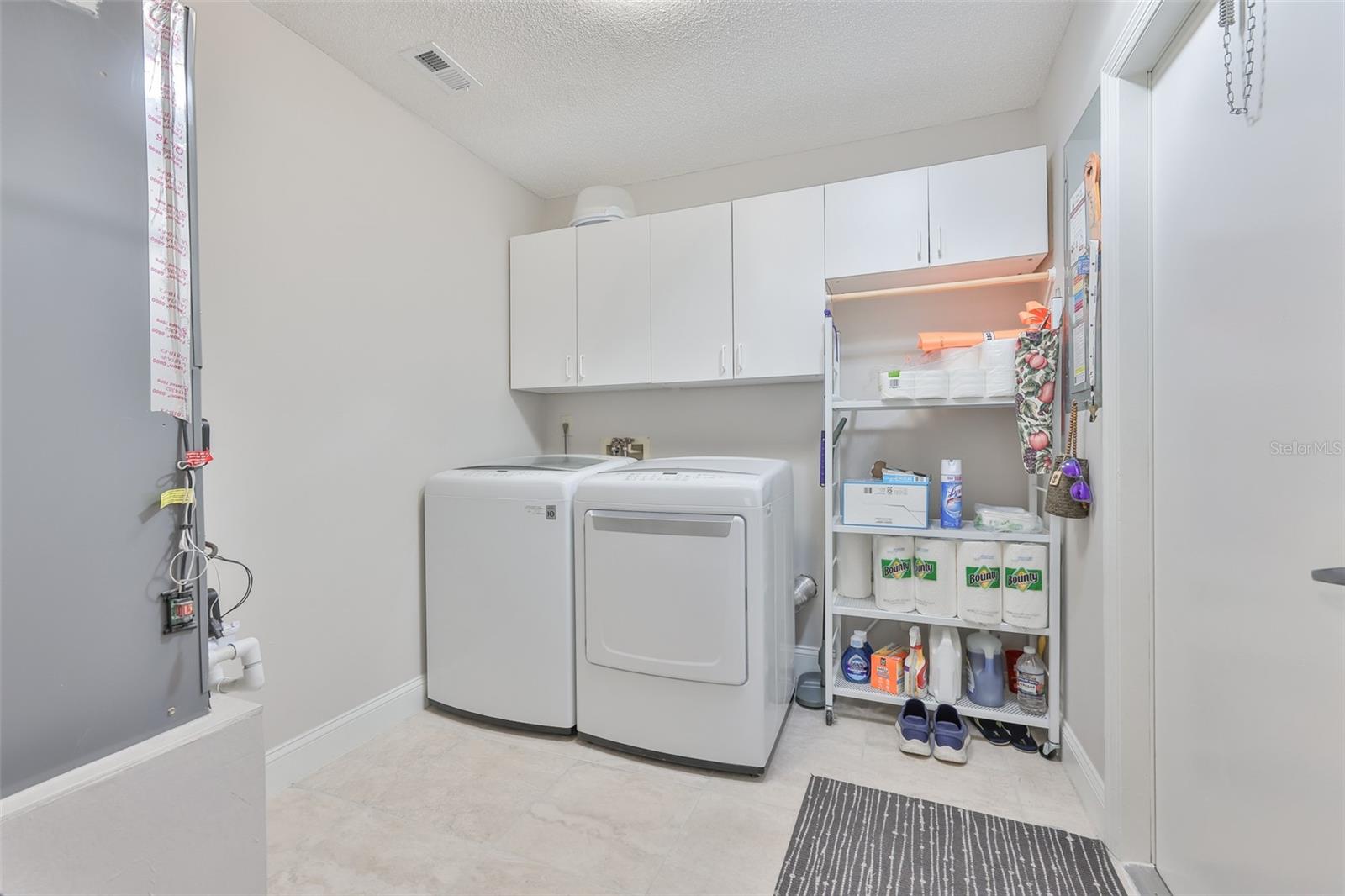 Laundry room is huge with newer appliances and cabinetry, and tile flooring.