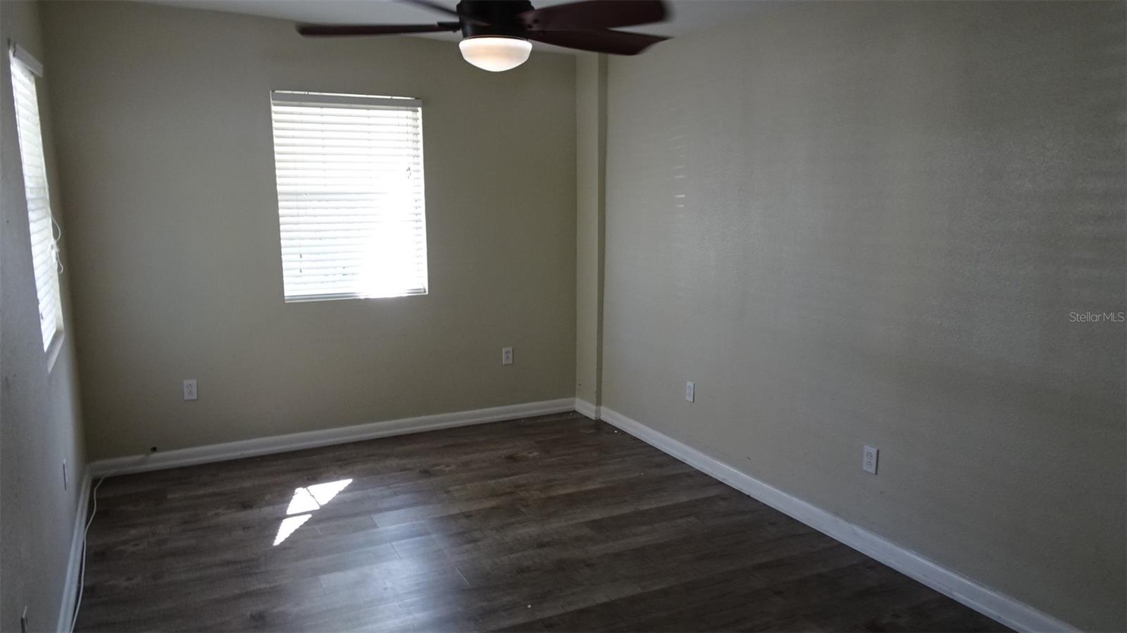 half of primary bedroom with a modern ceiling fan