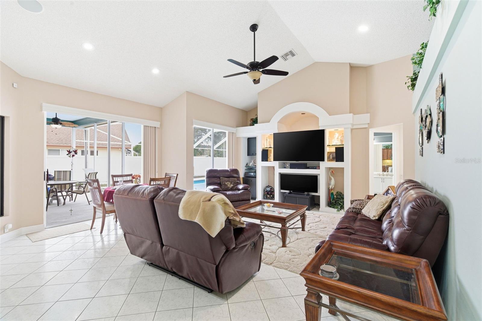 Great Room with recessed lighting, high ceilings, and multiple sliding doors offering access to the deck and pool area.
