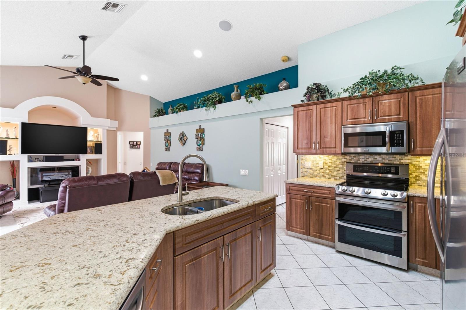 The kitchen includes a built-in double oven and an electric range that can be easily converted to propane gas for added cooking flexibility.