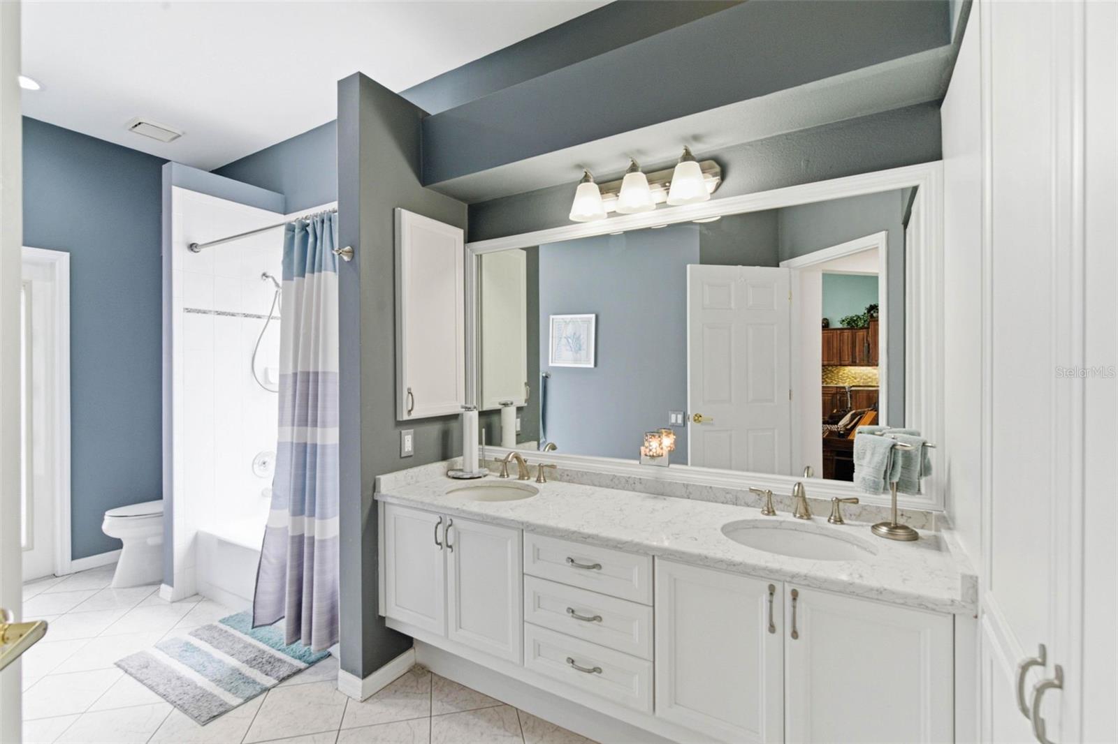 Updated full guest bathroom featuring dual sinks and a spacious vanity for added convenience.