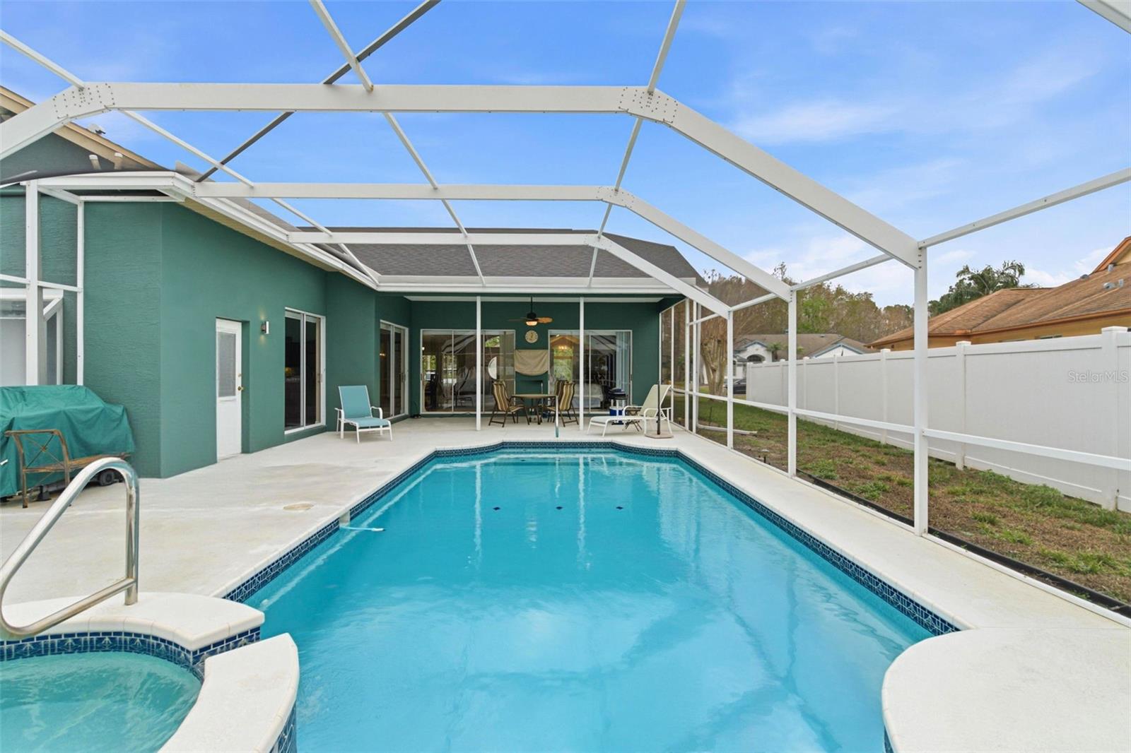 Screen enclosed lanai featuring the swimming pool and attached in-ground spa.
