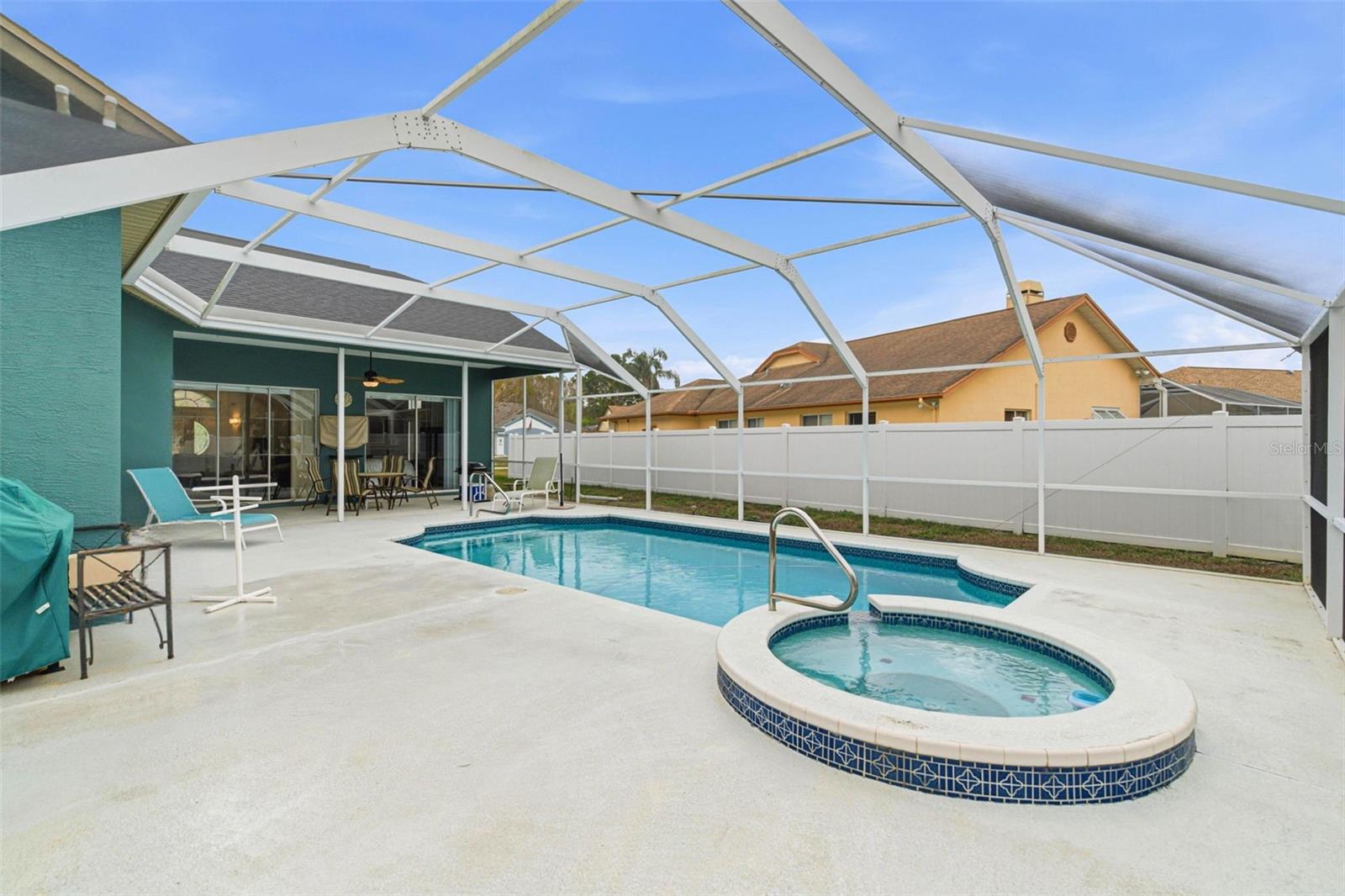Deck area wrapping around the pool and connected spa.