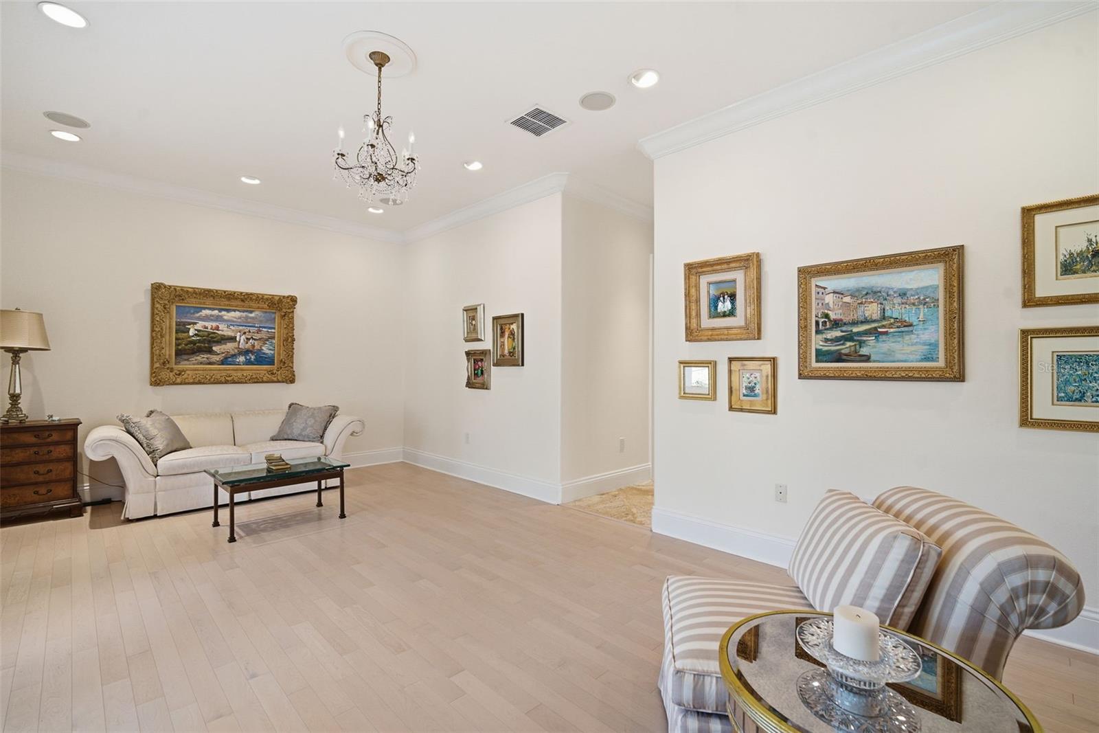 View looking from family room fireplace towards the entry hallway to full pool bath, laundry room and two car garage.