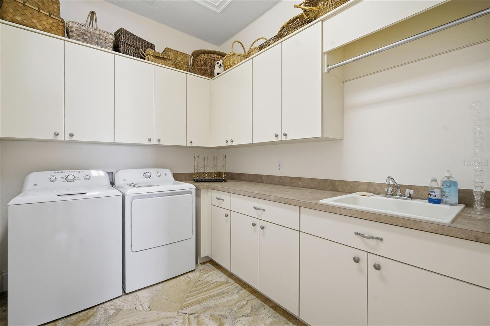 Laundry room with hanging area and drop sink, Ironing board, loads of cabinet space. Dryer is electric but there is a gas bib if you want to convert
