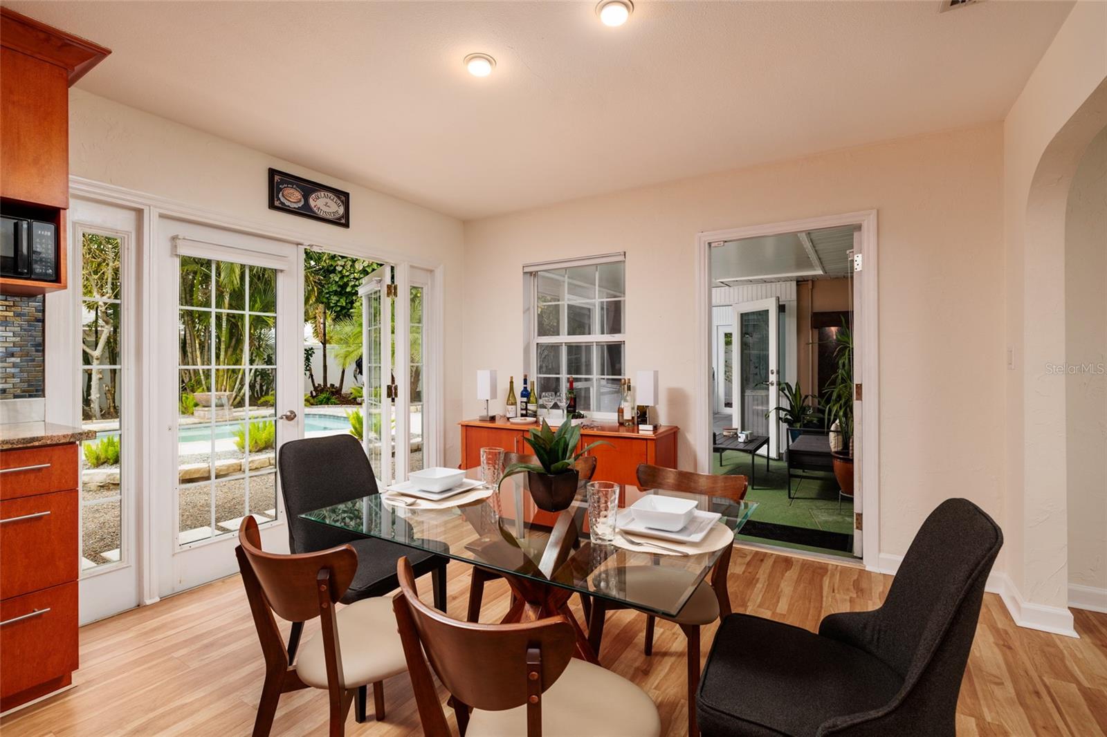 Dining space with seamless flow to both the screened porch and poolside patio through elegant French doors.