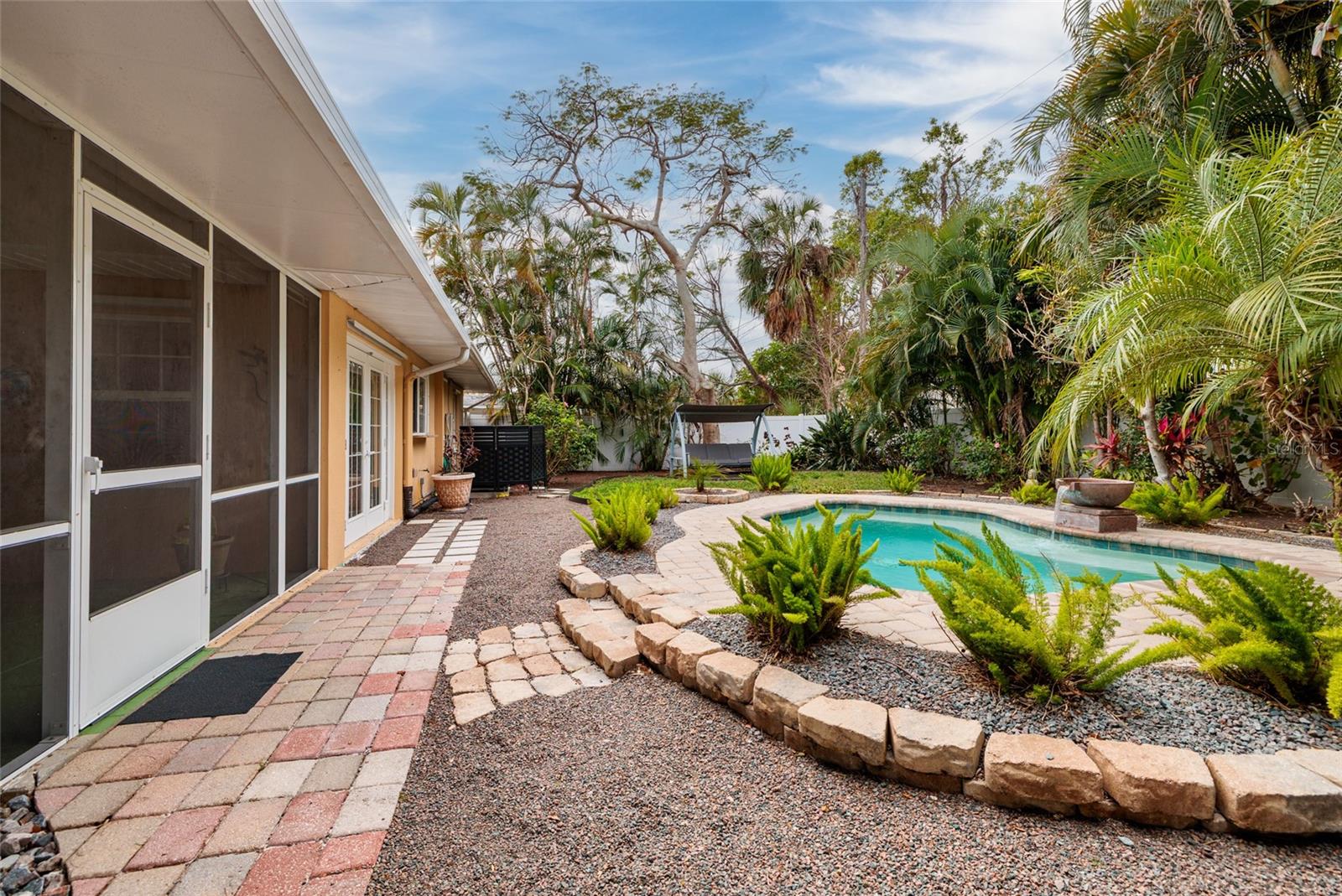Outdoor oasis with meandering wall and pebble pathways...very zen.