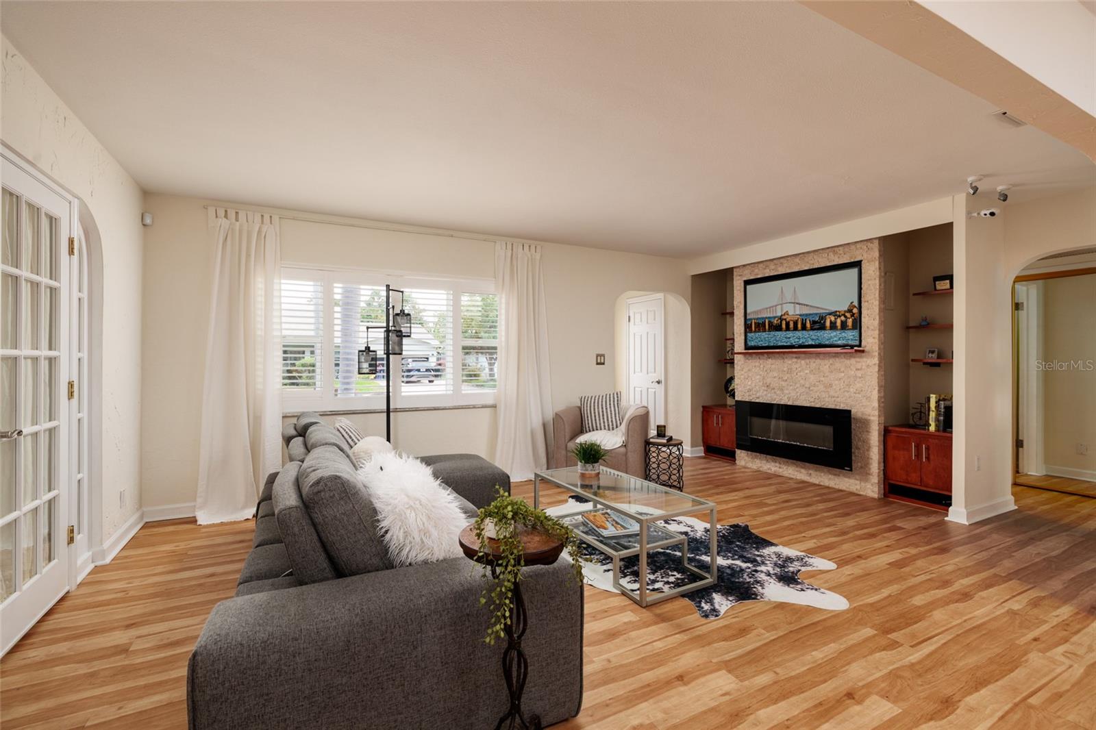 Sleek electric fireplace on stone feature wall with built in's and floating shelf accents.