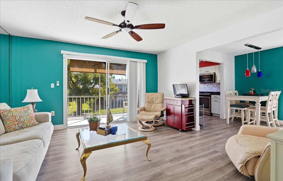 View from living room toward slider to dining room and kitchen in the background on right