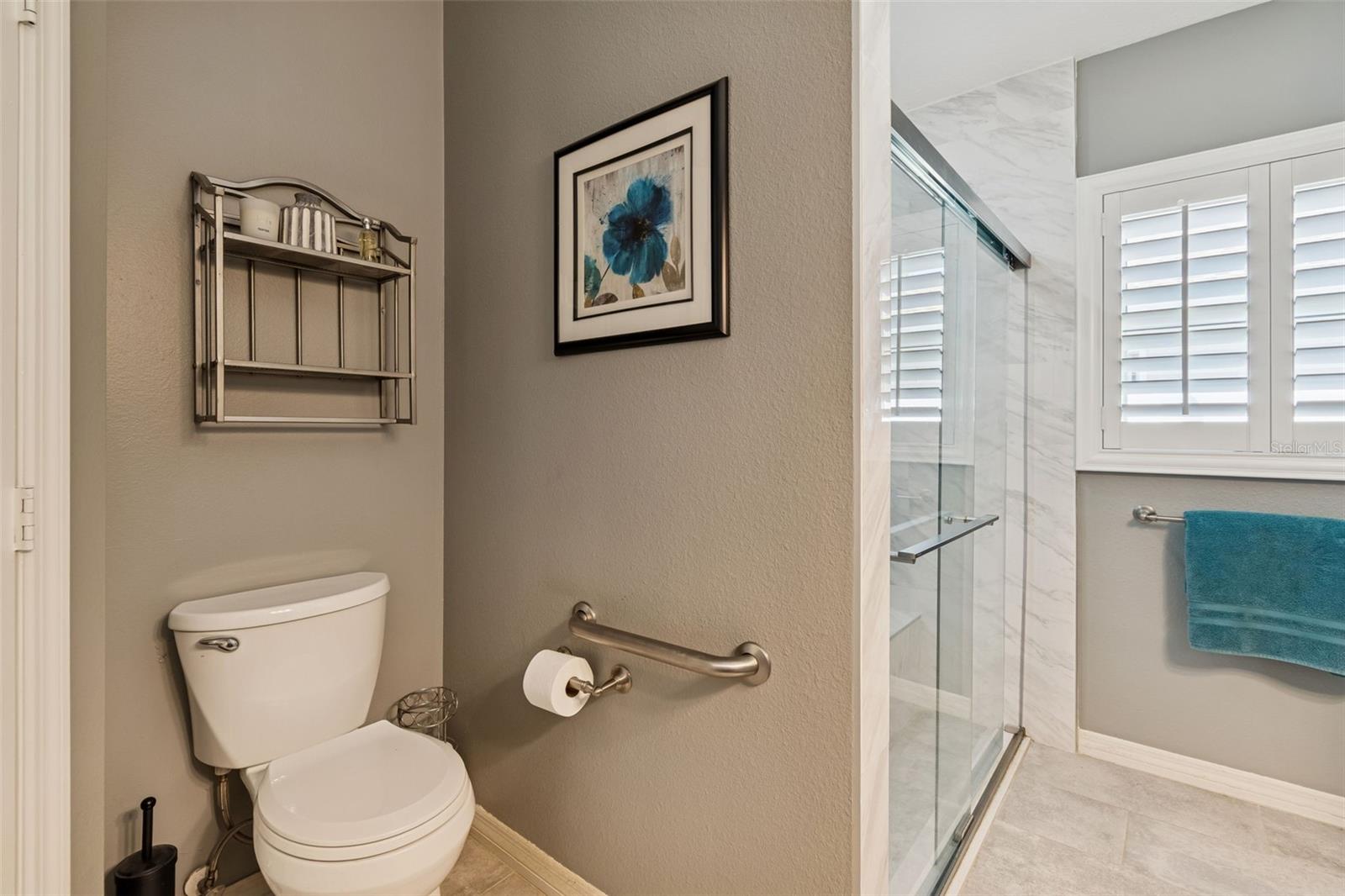 Your bathroom window with Plantation shutters brings in the natural light.