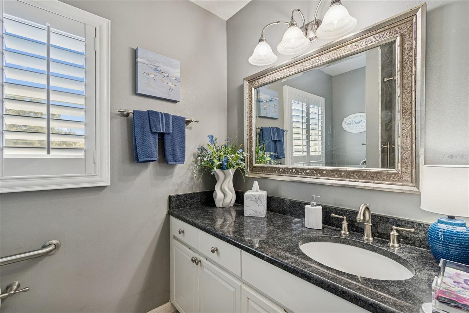 Your bathroom window with Plantation shutters brings in the natural light.