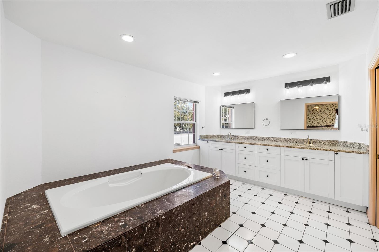 Huge en-suite master bathroom with a large soaking tub, double sinks and separate shower area