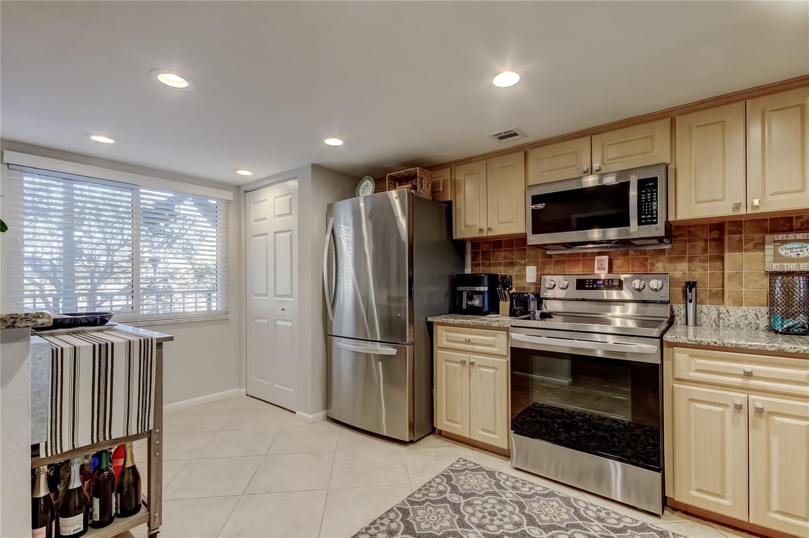 Kitchen with stainless steel appliances and closet with washer and dryer.