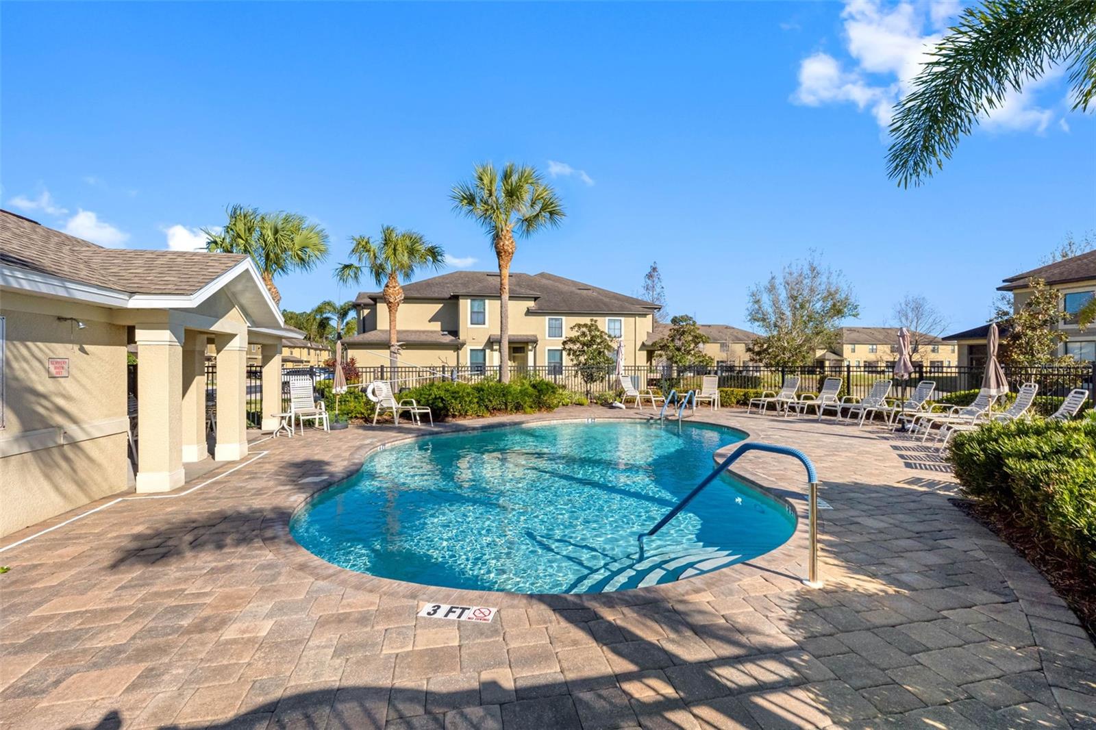 Resort-style community pool surrounded by tropical landscaping—perfect for relaxing on warm Florida days.