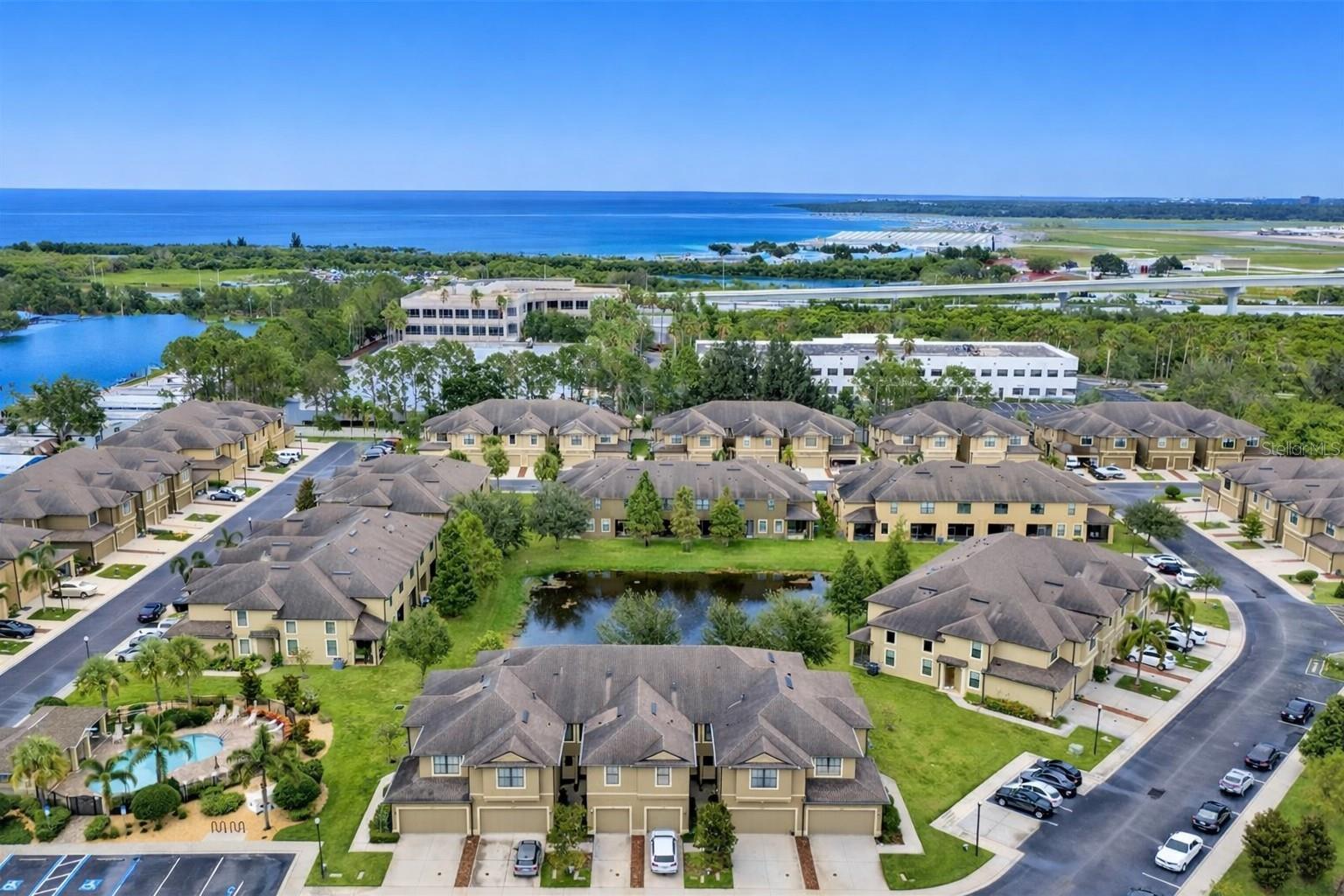 Bird’s-eye view of Bay Isle Landings, showcasing the gated layout, community pool, ponds, and central Clearwater location.