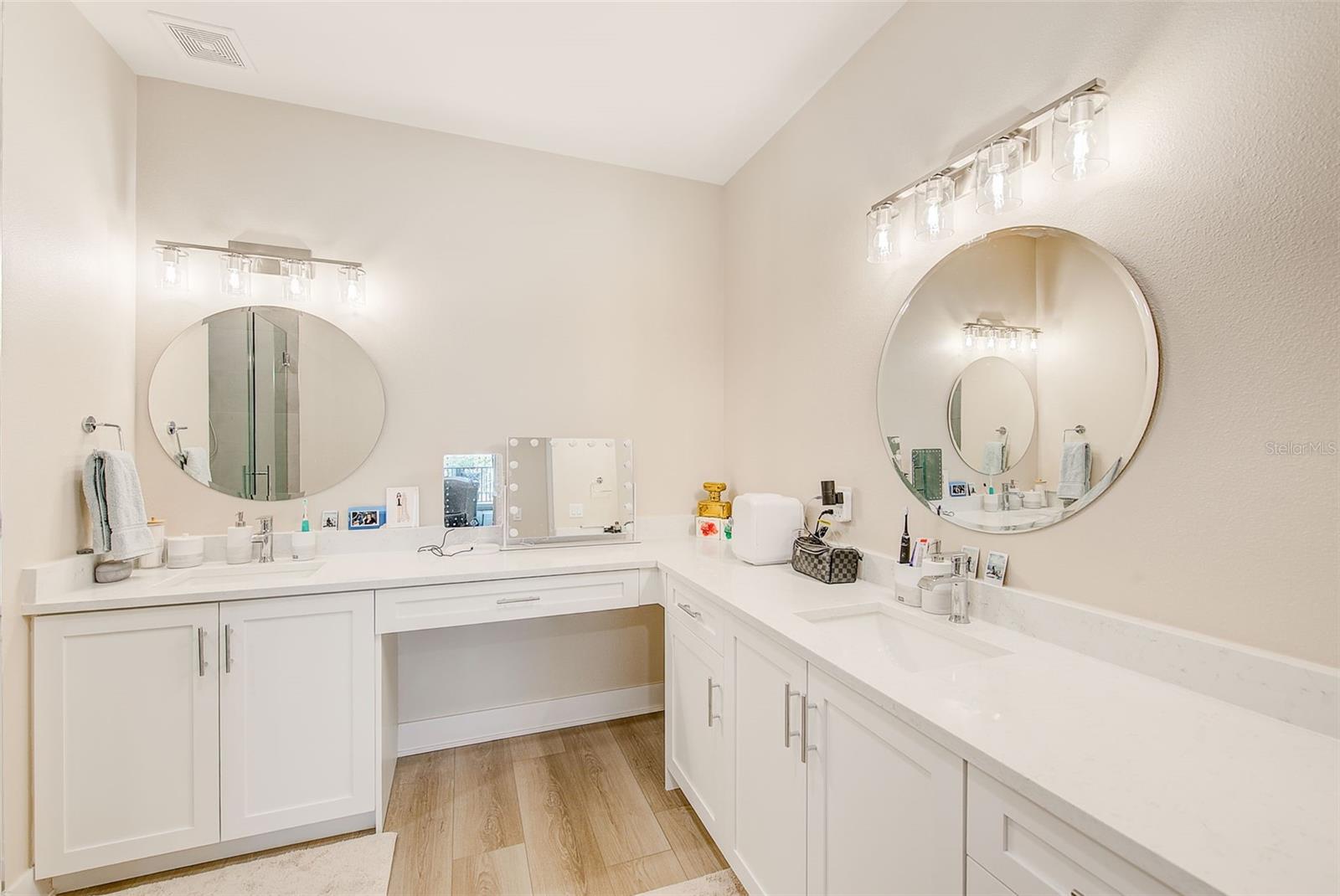 Dual sink and vanity with quartz countertops.