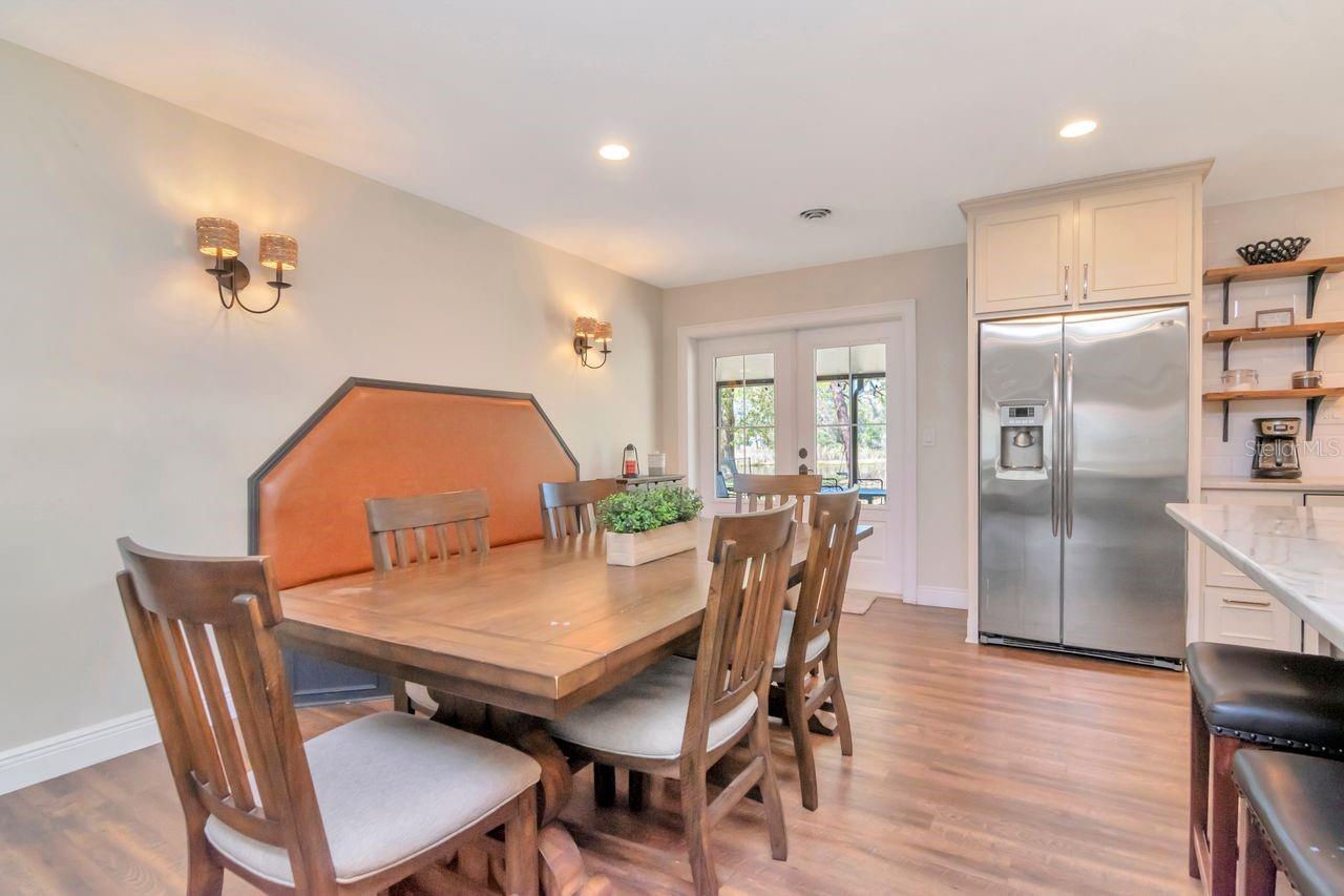 Dining Room and Built in Bench Seating with French Doors Leading to Covered & Screened Lanai