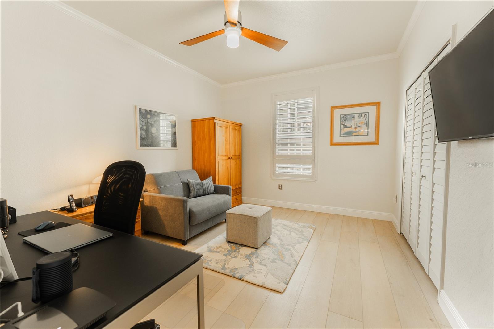 The second bedroom features elegant LVP flooring, a spacious closet with ample storage, and is adorned with a charming window shutter.