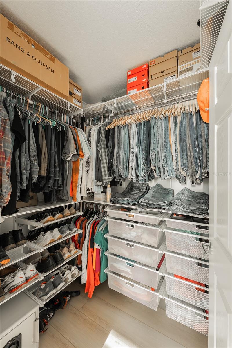 The custom-designed primary bedroom walk-in closet boasts an abundance of storage space.