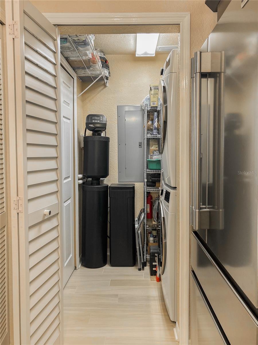 Convenient laundry room just off the kitchen, featuring a new washer and dryer, a water softener, and ample additional storage.