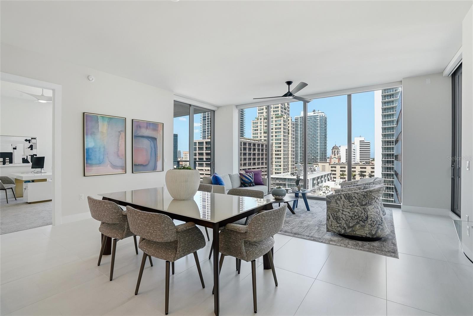 Bright dining and living area with floor to ceiling windows bringing natural light and beautiful downtown St. Petersburg views inside.