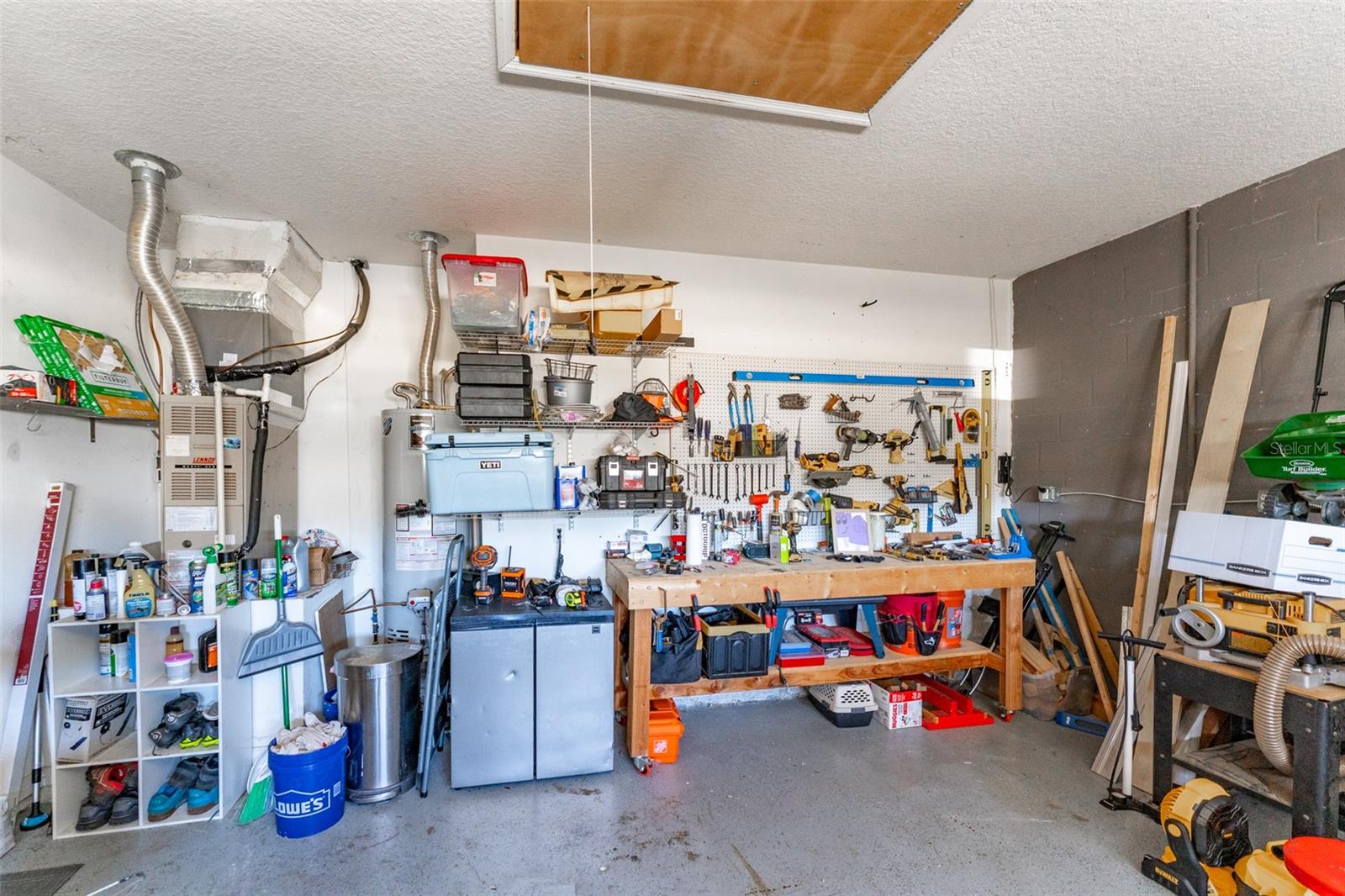 work bench with peg board & pull down attic stairs in the 2 car garage. Items in photo DO NOT CONVEY.
