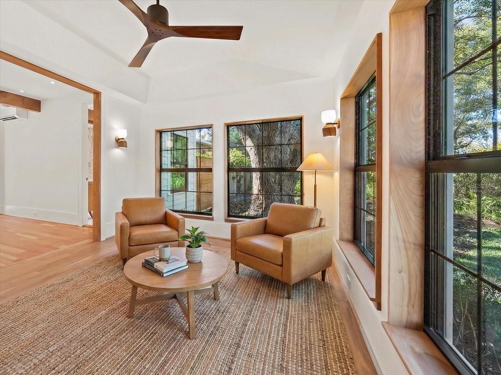 Primary suite sitting room/study with cove ceiling, gorgeous windows and wall sconces. Virtually staged