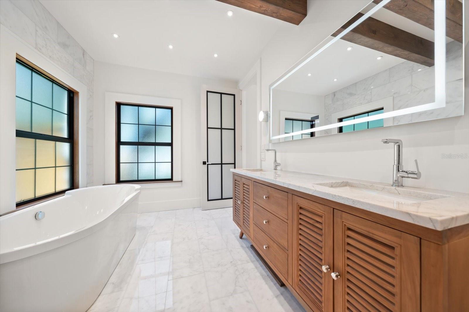 Primary en suite bath, Duravit soaking tub, LED mirror, dual sinks, frosted glass windows and door
