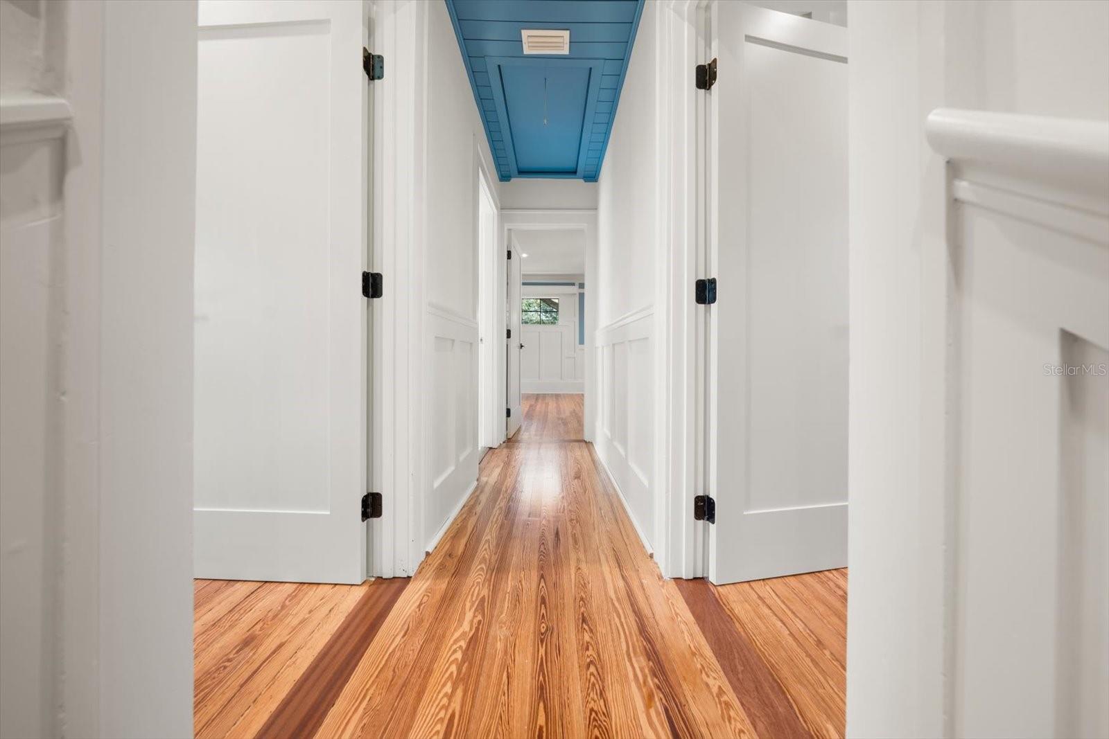 Upstairs hallway to 3 additional bedrooms with shiplap ceiling