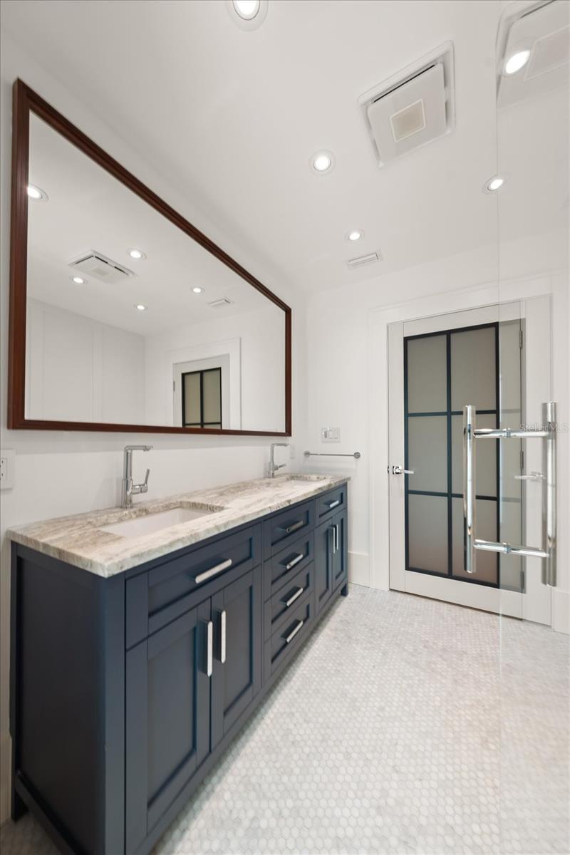 Hall bath with dual sinks, beautiful shower, solid wood cabinetry with organizational compartments built in the drawers, leathered granite countertop