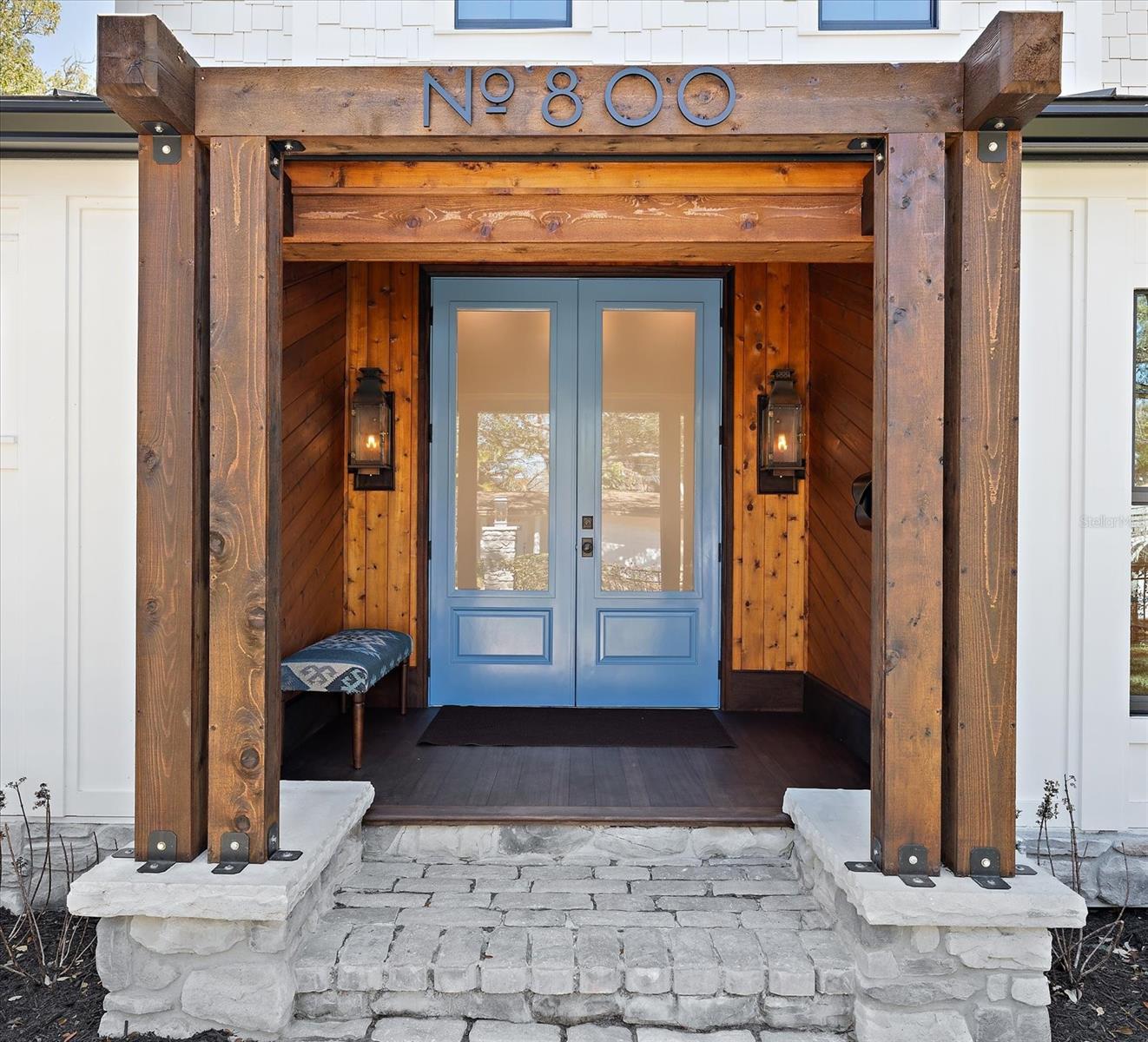 Front porch with cedar tongue & groove walls, mahogany flooring and gas lanterns
