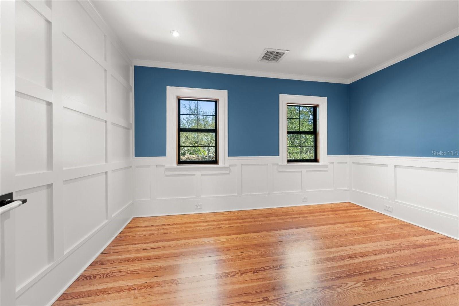 Bedroom #4 with shaker accent wall and wall panels, crown molding, large windows, and walk in closet with custom built in drawers with marble countertop.