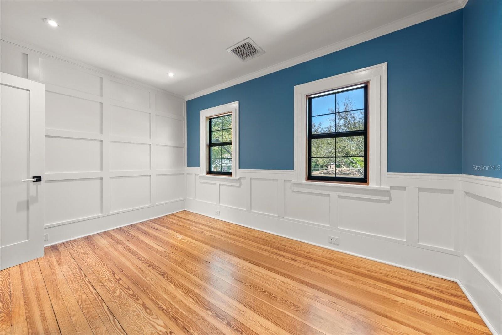 Bedroom #4 with shaker accent wall and wall panels, crown molding, large windows, and walk in closet with custom built in drawers with marble countertop.