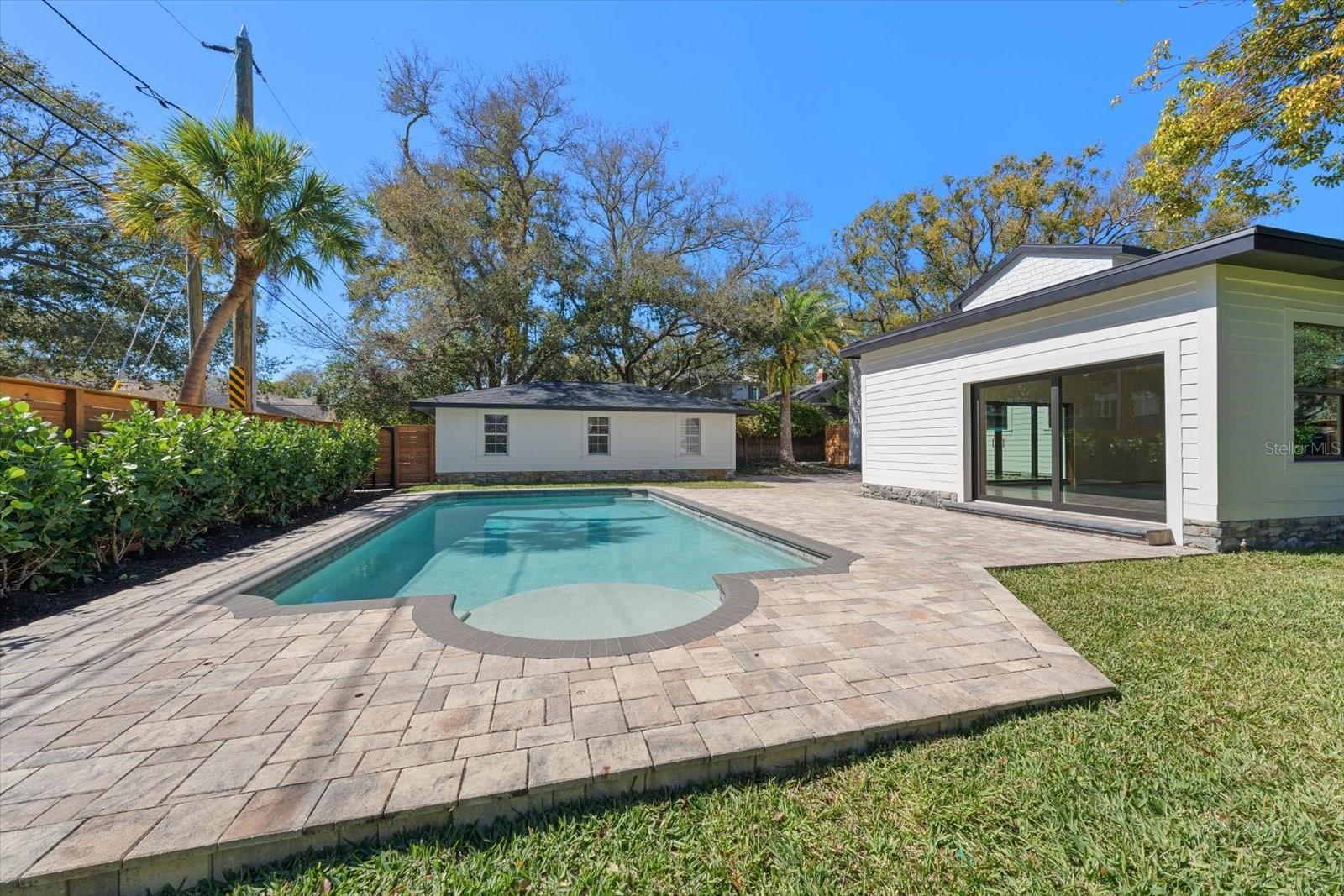 Expansive brick paver backyard living/entertaining space. Surrounded by lush landscaping, lots of grass and beautiful 7' deep pool with sunshelf and lighting.  Oversized 2 car garage with alley access.