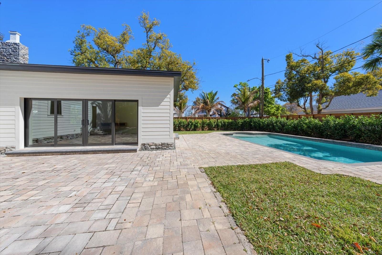 Expansive brick paver backyard living/entertaining space. Surrounded by lush landscaping, lots of grass and beautiful 7' deep pool with sunshelf and lighting.